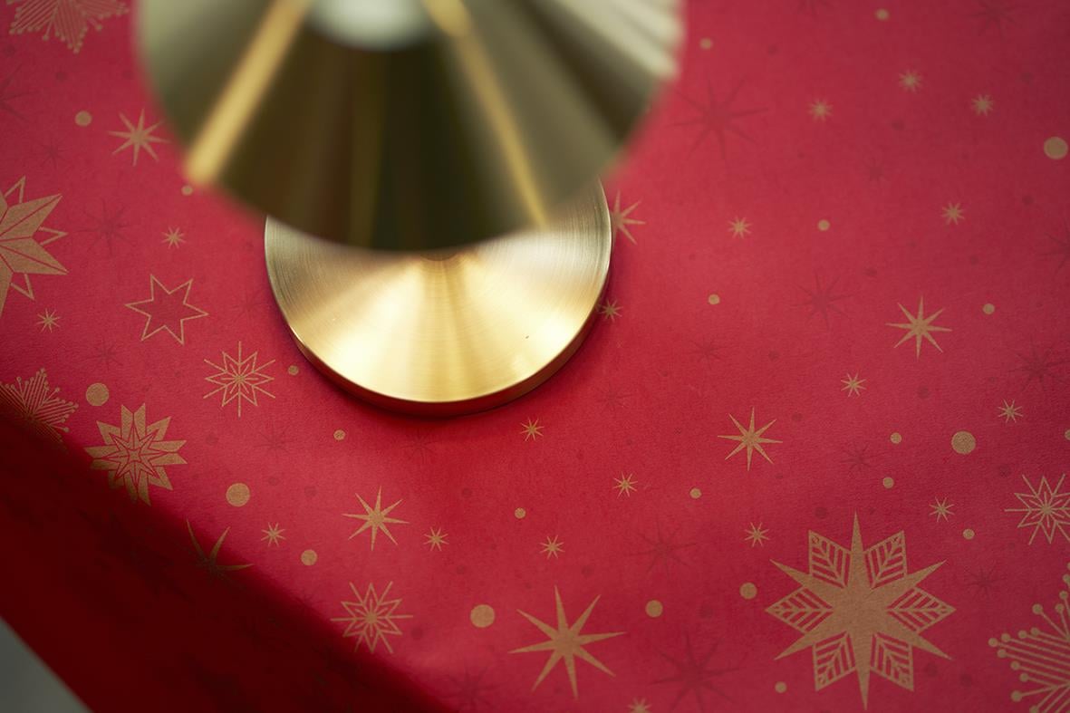 Röd duk med stjärnmönster och ett guld- och svart ljusstake