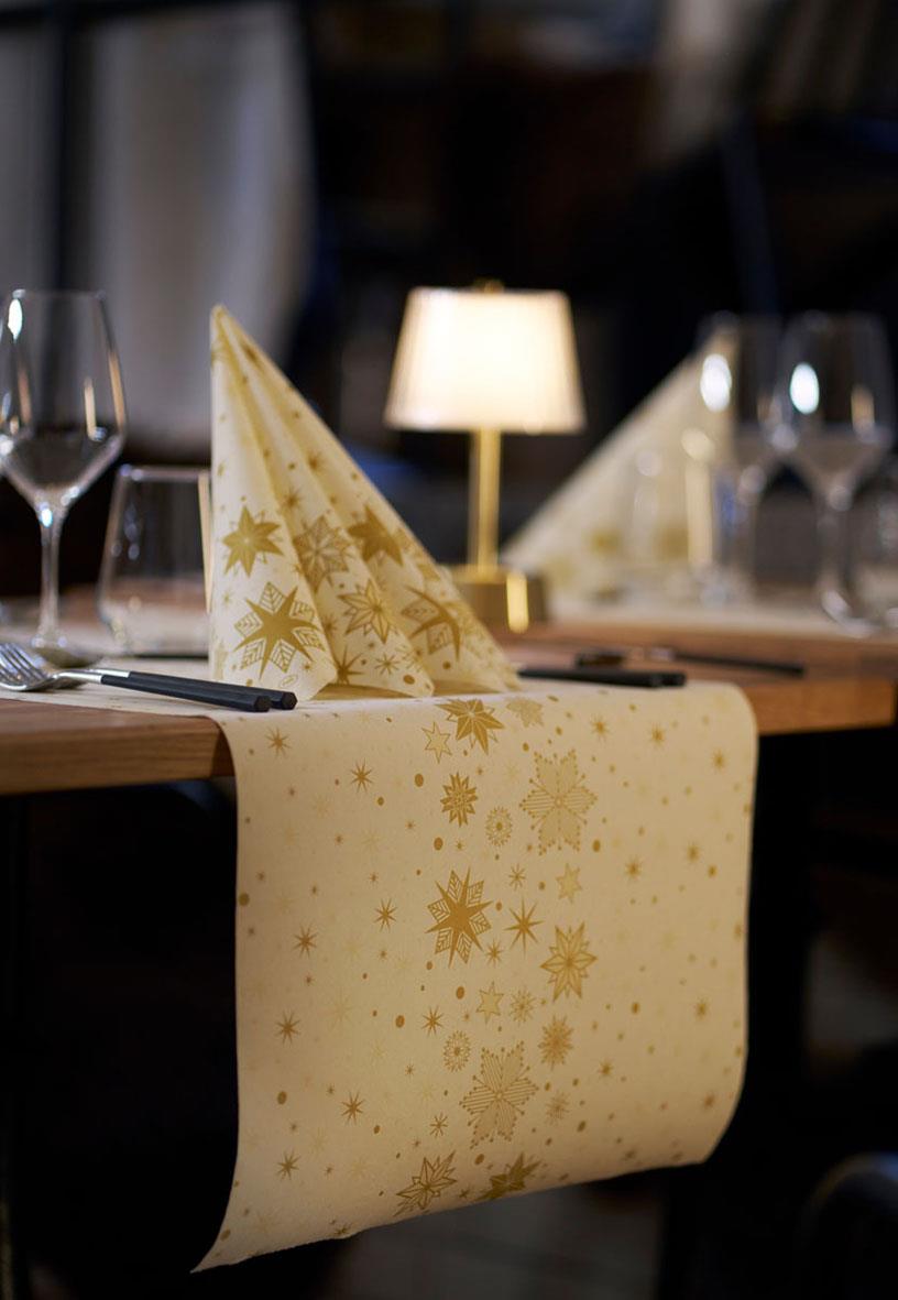 Vepa Duni Stargazing Cream bio dunicel väggbonad med guldstjärnor och snöflingor på ett bord med glas och bestick
