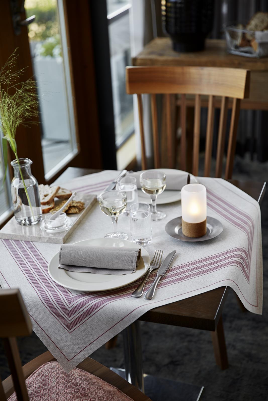 Servett Duni Dunilin i granitgrå på ett dukat bord med glas, ljus och bestick i ett mysigt hem.