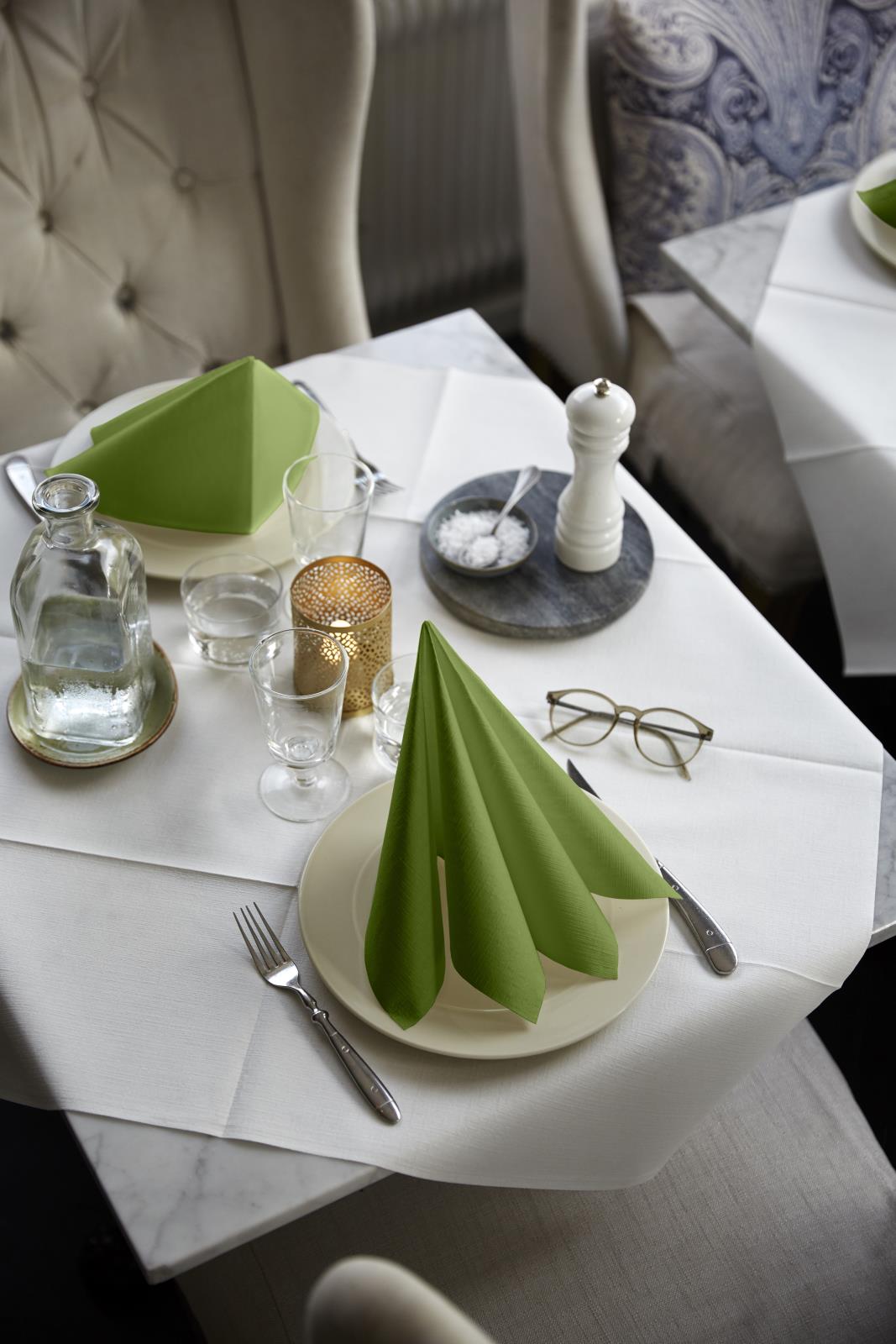 Servett Duni Dunilin Leaf Green 40x40cm på dukat bord med glas, salt och peppar, bestick och ljuslyktor