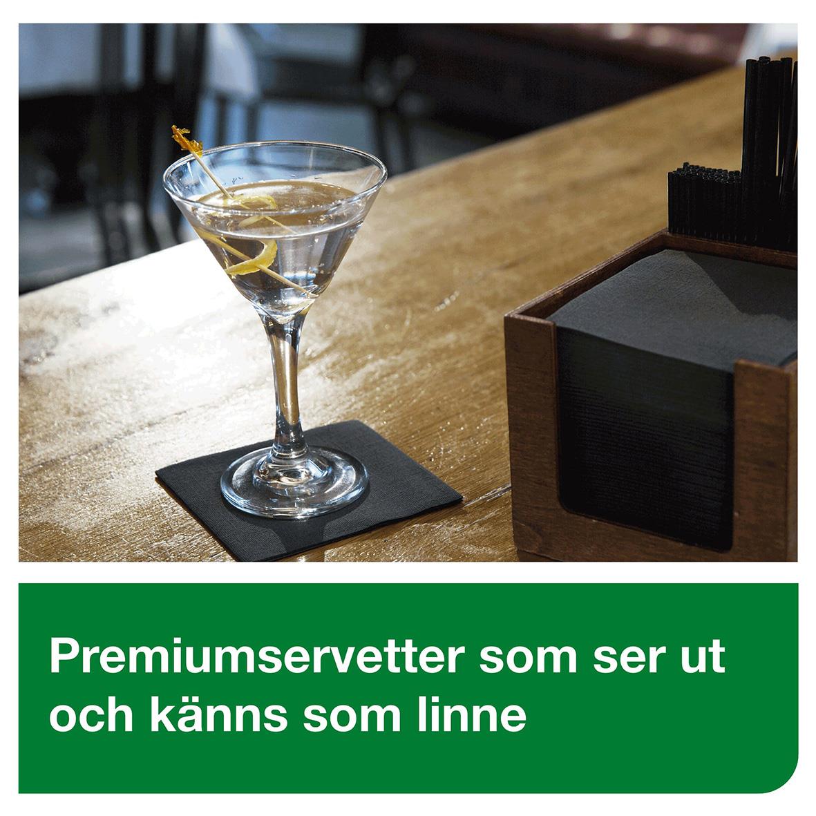 Svart servett under en cocktailglas på ett träbord med en box av servetter i bakgrunden