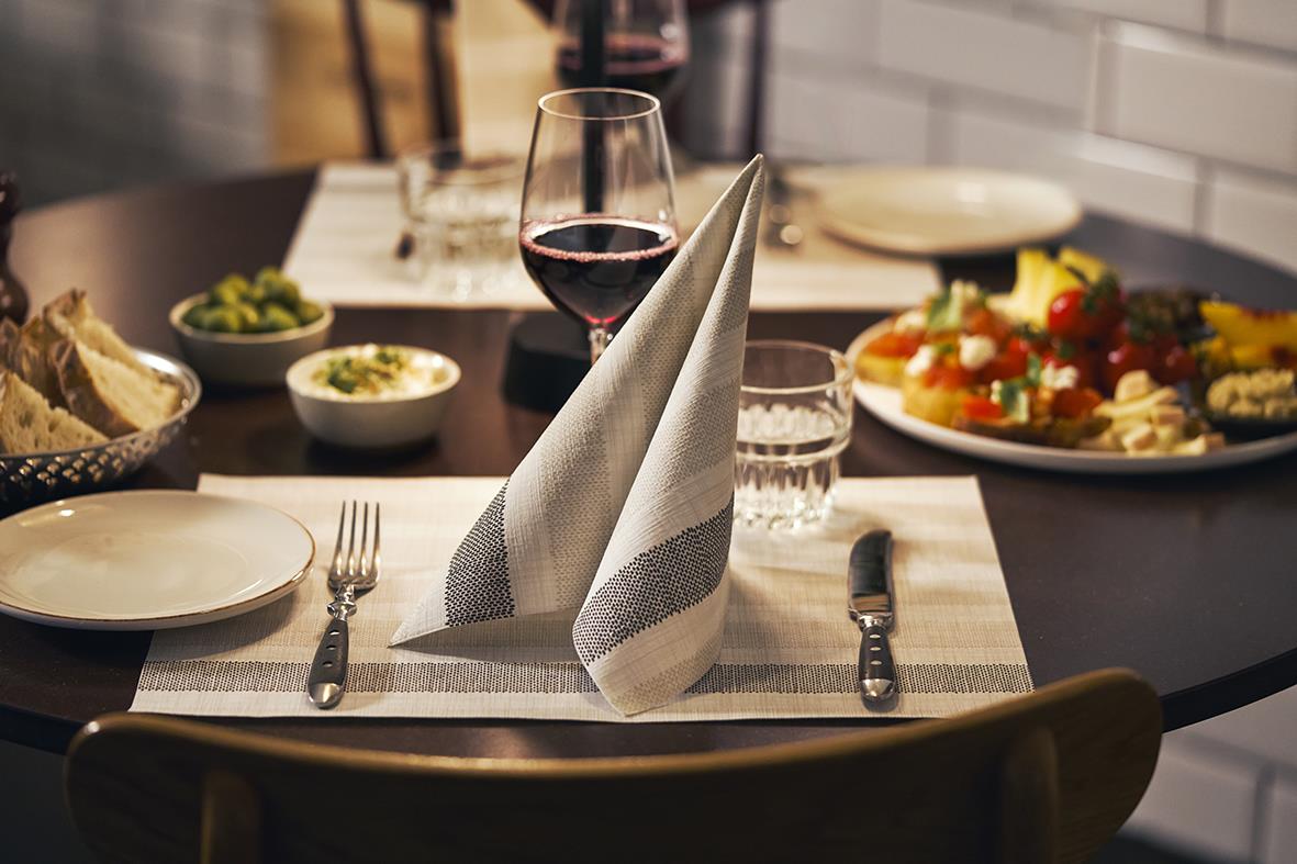 Servett Duni Dunilin Rigato svart 40x40cm på dukat bord med glas vin och mat i bakgrunden