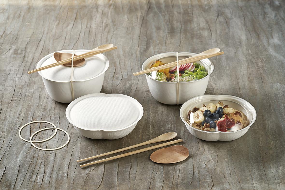Set med små skålar, träbestick och gummiband på träbord
