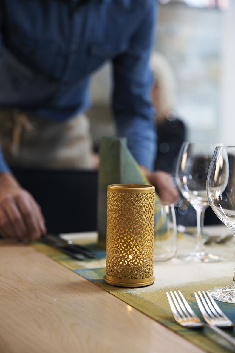 Guldig ljushållare Duni Bliss på dukat bord med glas och bestick