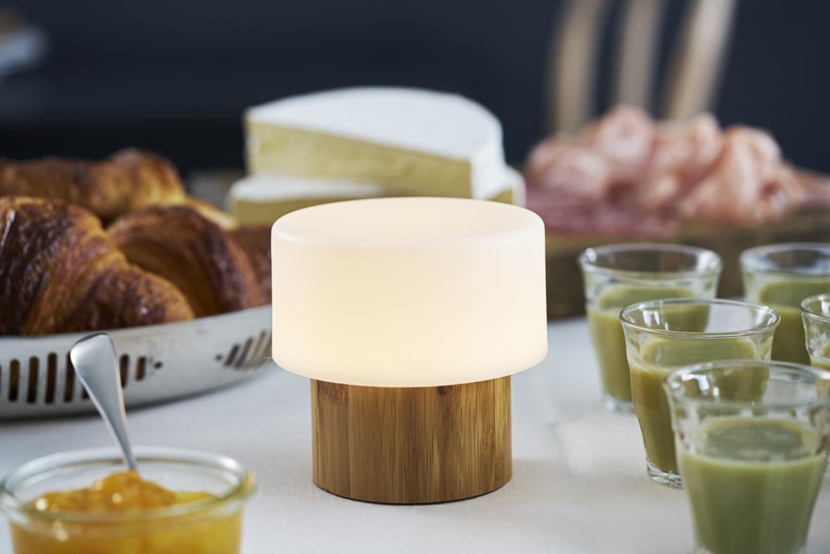 LED ljushållare Duni Sister Bambu 110x110mm på bord med bakgrund av mat och dryck