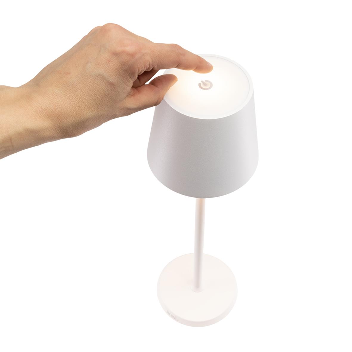 Hand som justerar en vit LED bordslampa med touchkontroll