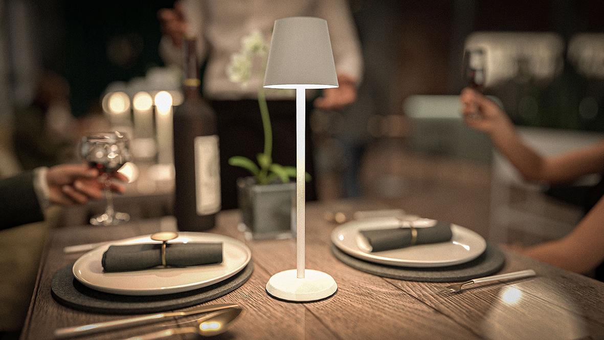 Bordslampa LED Securit Feline Vit på ett bord med tallrikar och bestick i ett restaurangmiljö