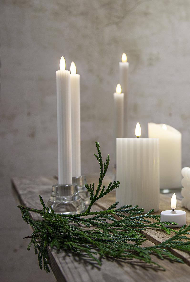 Antikljus LED Flamme Stripe Vit på ett bord med gröna grenar