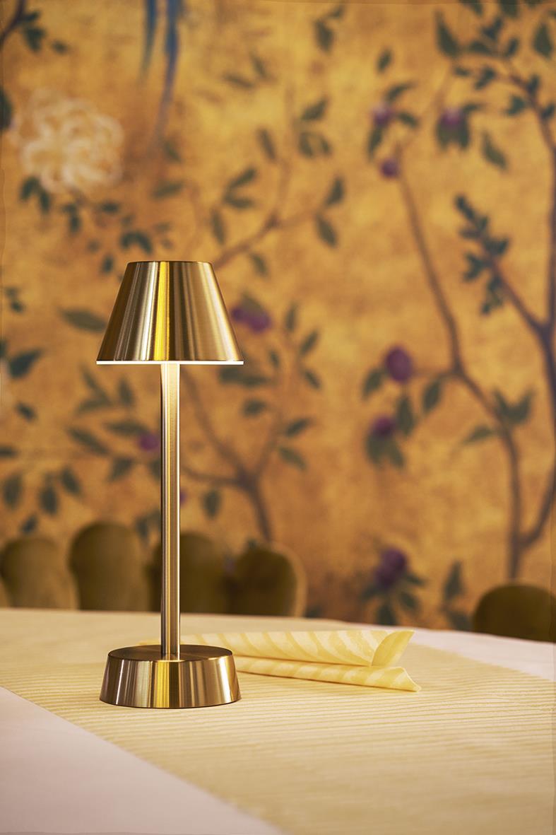 Bordslampa LED Duni Zelda i mässing på bord med bakgrund av blommig vägg