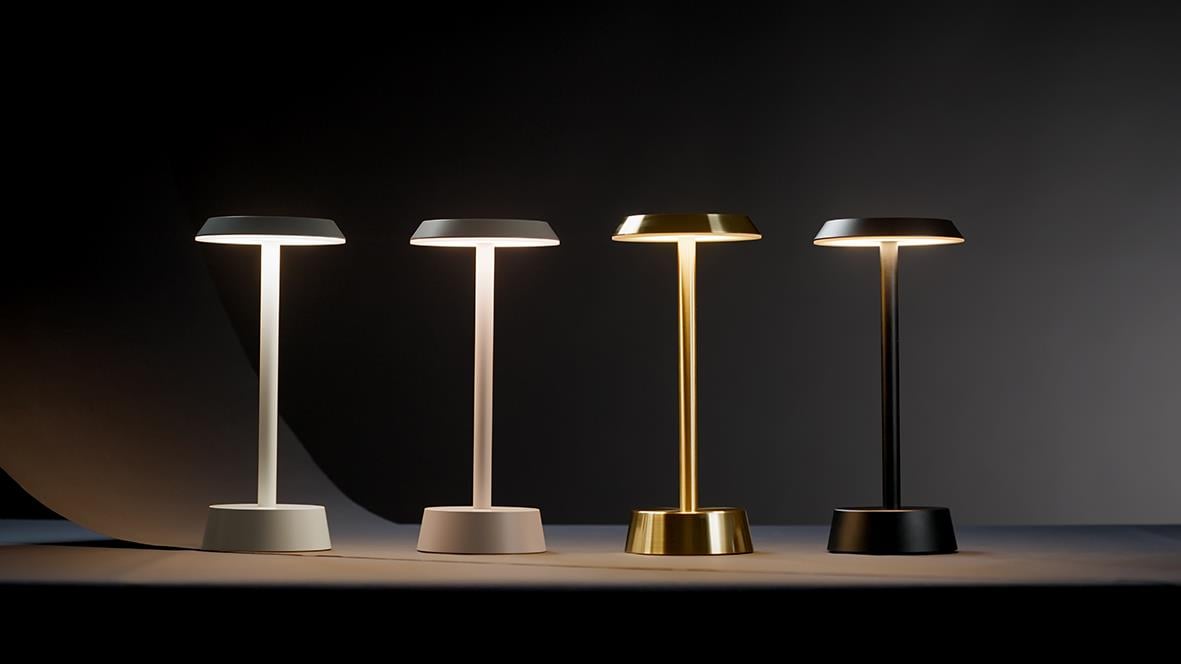 Fyra bordslampor i olika färger: vit, taupe, guld och svart