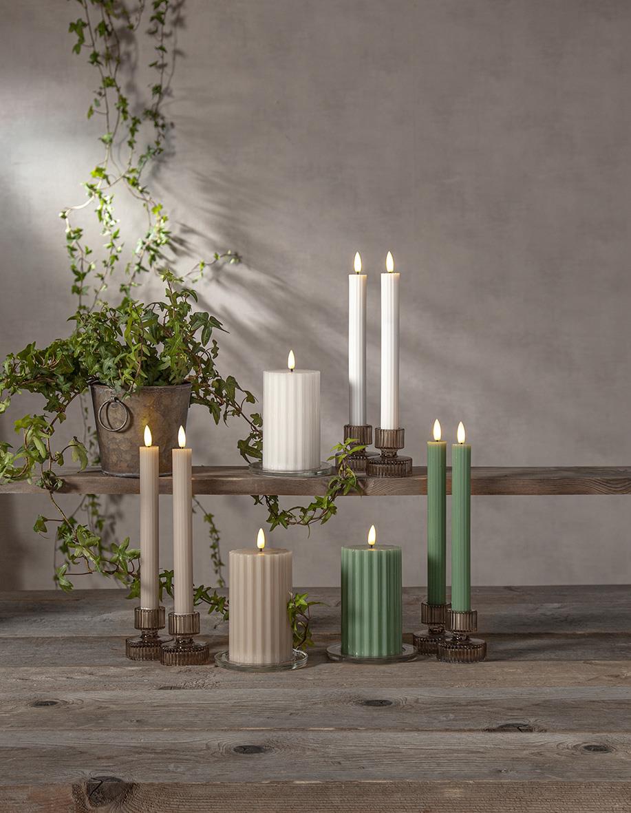 Antikljus LED Flamme Stripe i beige och grönt på träbord med växt i bakgrunden