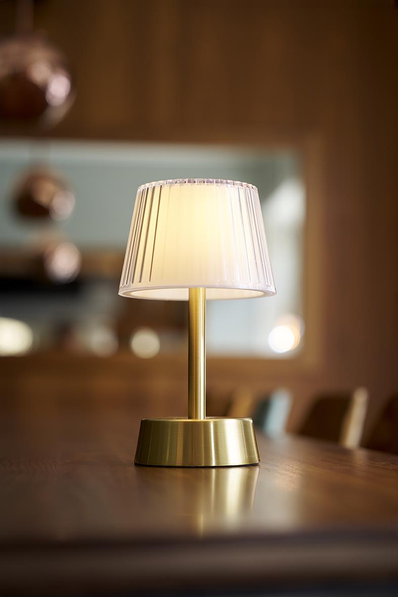 Bordslampa LED Duni Jay Guld med vit lampskärm och guldfärgad bas på ett träbord