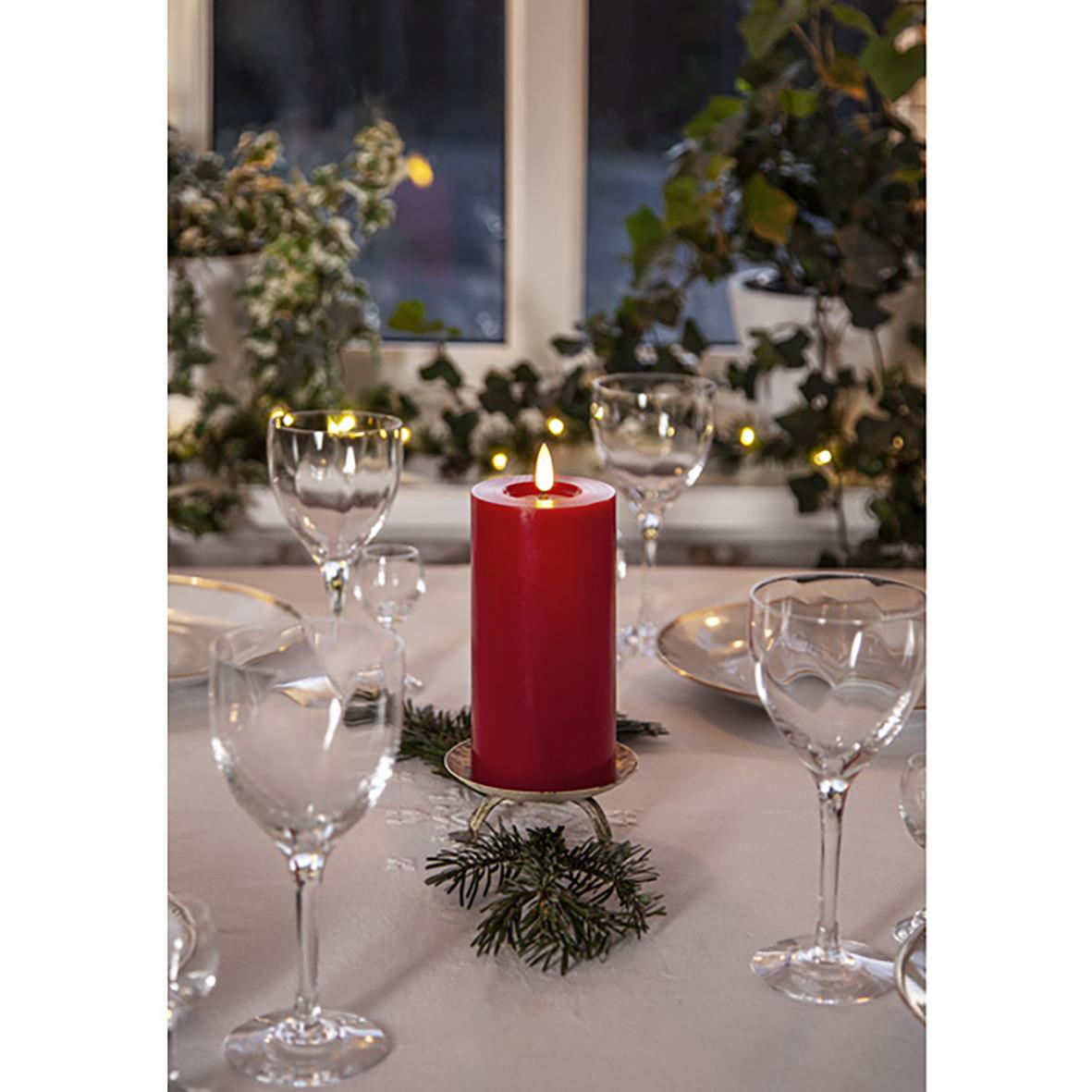 " LED Flamme Flow Röd på bord med glas och juldekorationer, skapar mysig stämning."