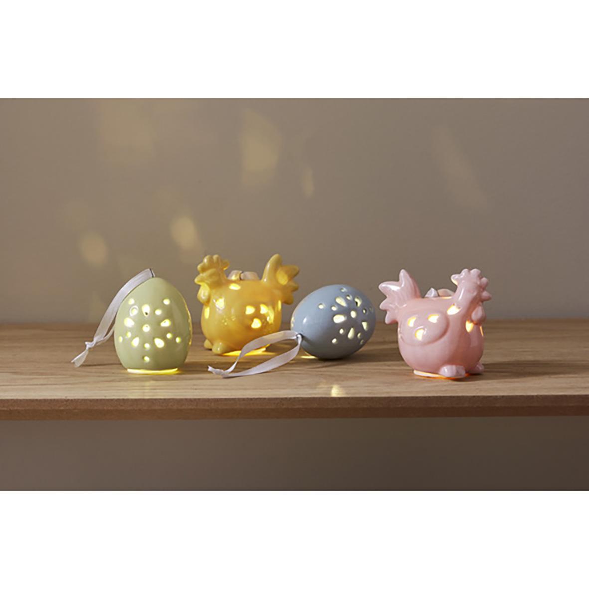 Färgglada dekorationsfigurer i form av ägg och djur på en träbänk