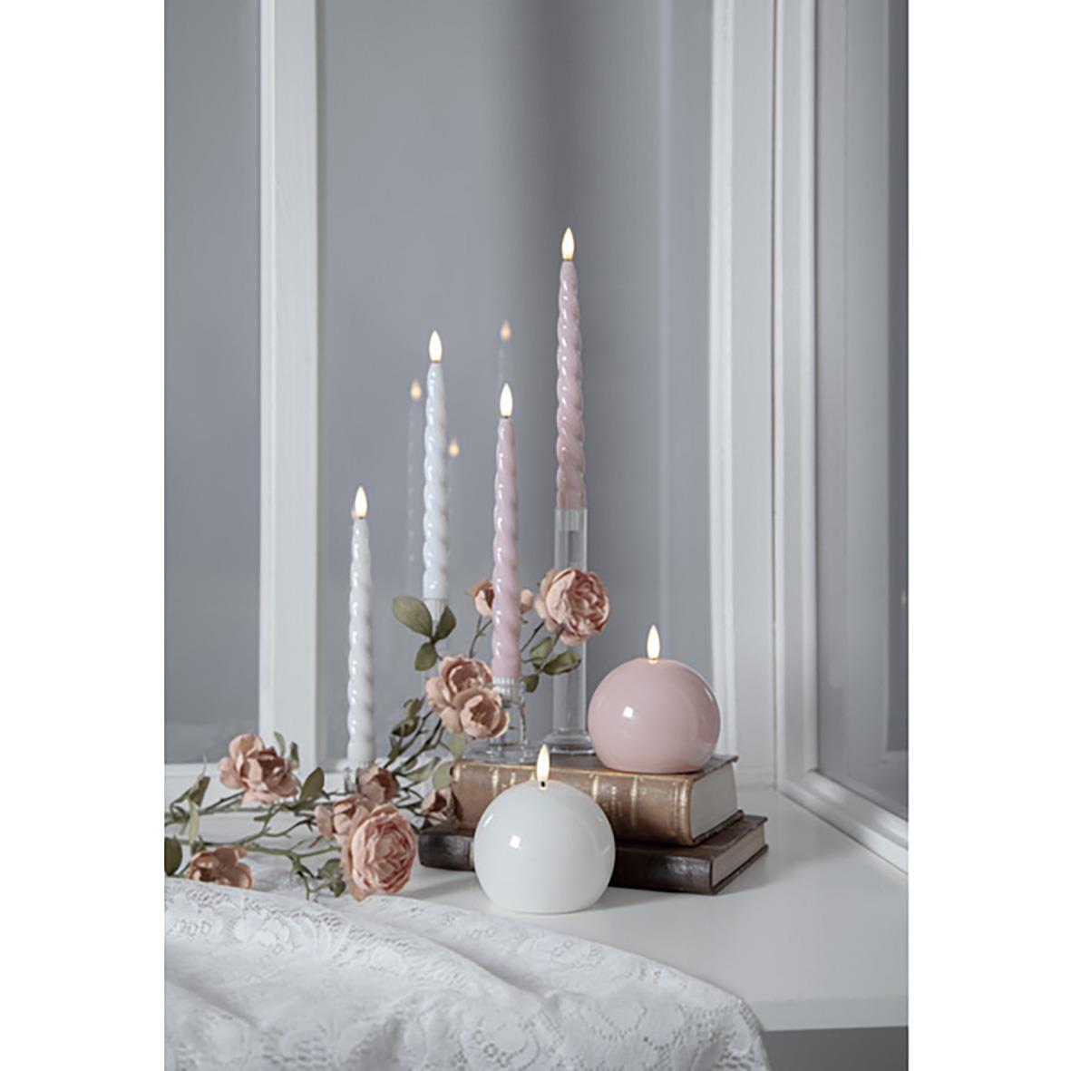 Antikljus Star Trading LED Flamme Shine Rosa med rosa och vita ljus och blommor på ett bord