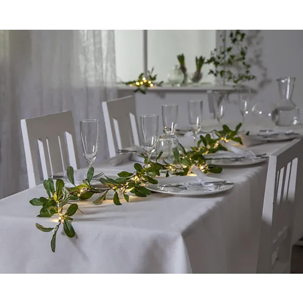 Grön mistelgirlang med stjärnor på dukat bord för juldekoration