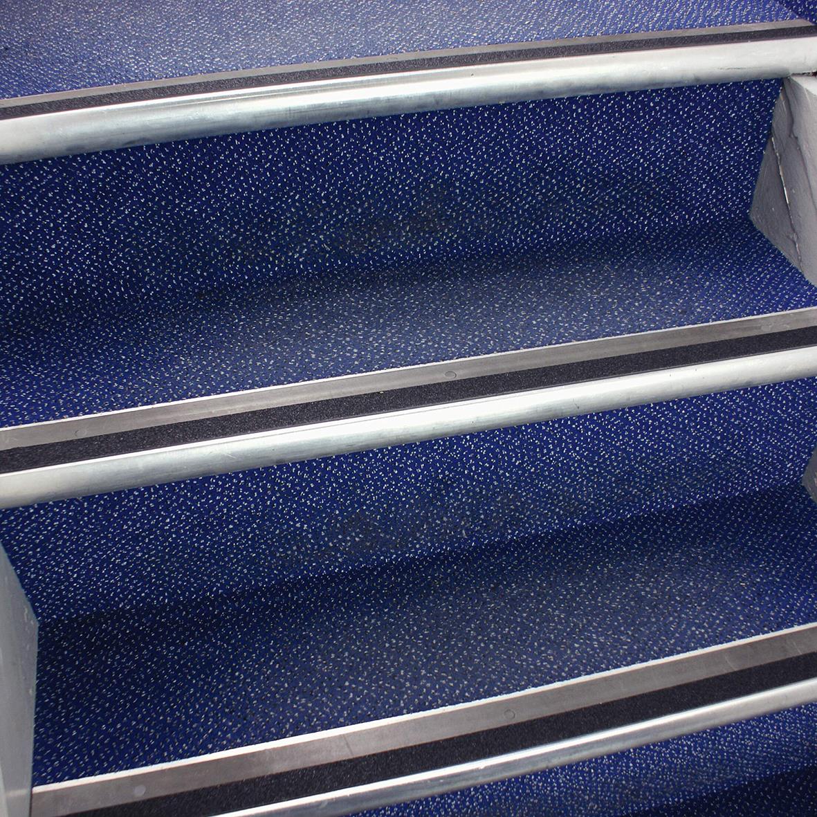 Svart halkskyddstejp på trappsteg med silverfärgade kanter