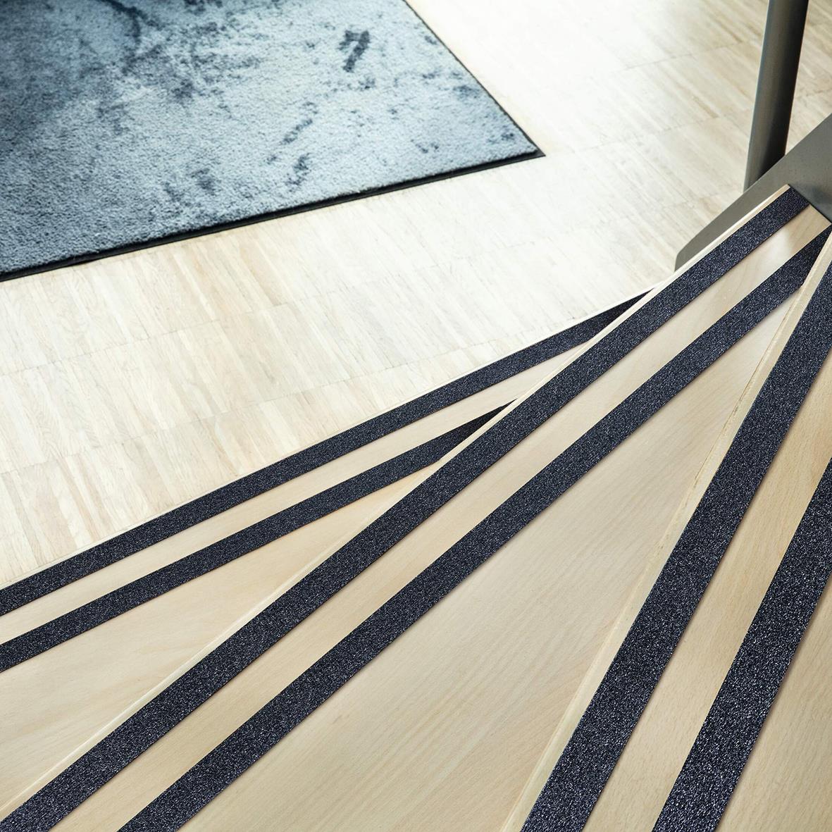 Svarta halkskyddstejpbitar på golv, för säkrare steg