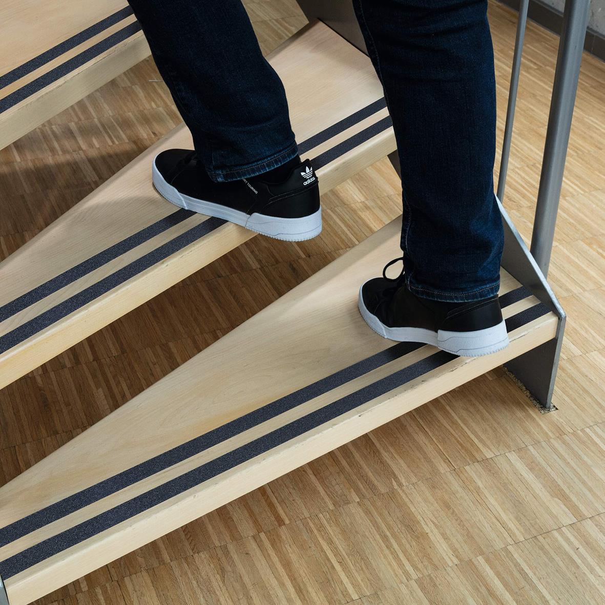 Person står på svart halkskyddstejp på träbänk, visar produktens användning och greppvänlighet