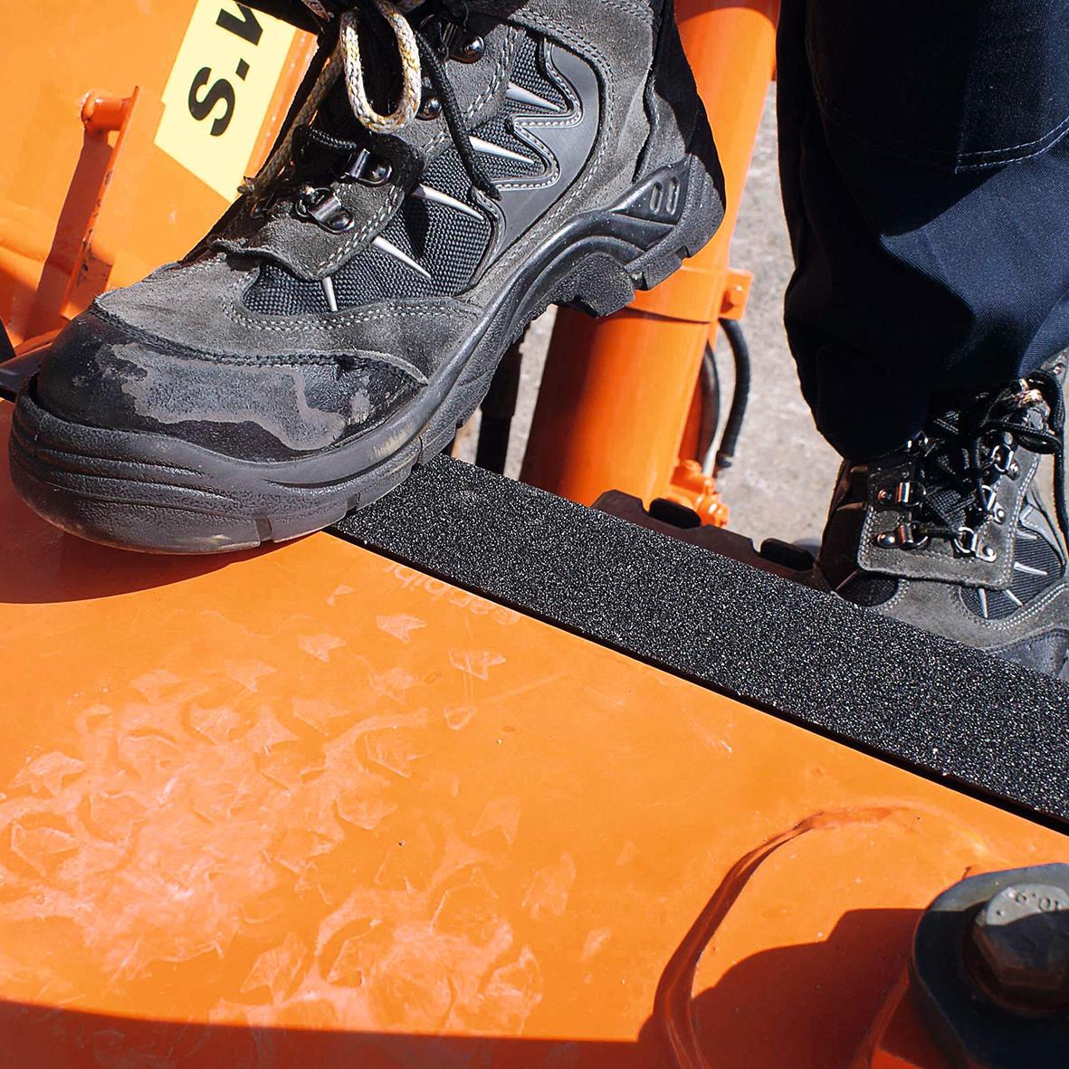 Svart halkskyddstejp på en orange maskin, används för att ge bättre grepp och säkerhet