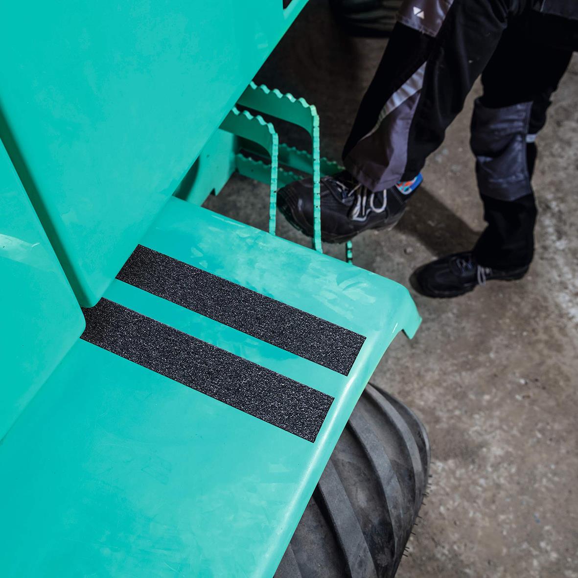 Svart halkskyddstejp på trappa av plast, monterad för säker gång