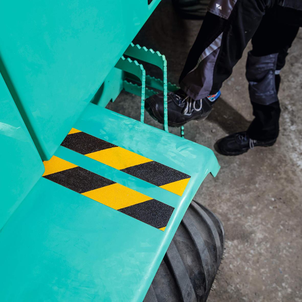 Halkskyddstejp på trappa i gul och svart för att markera farligt område