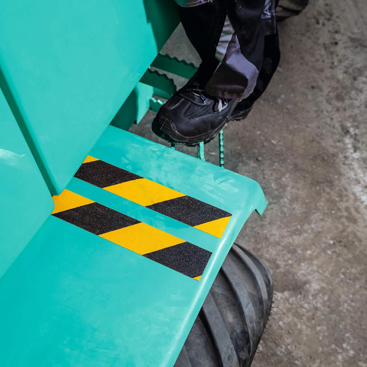 Halkskyddstejp på trappa med gul/svart varningsmönster för säkerhet