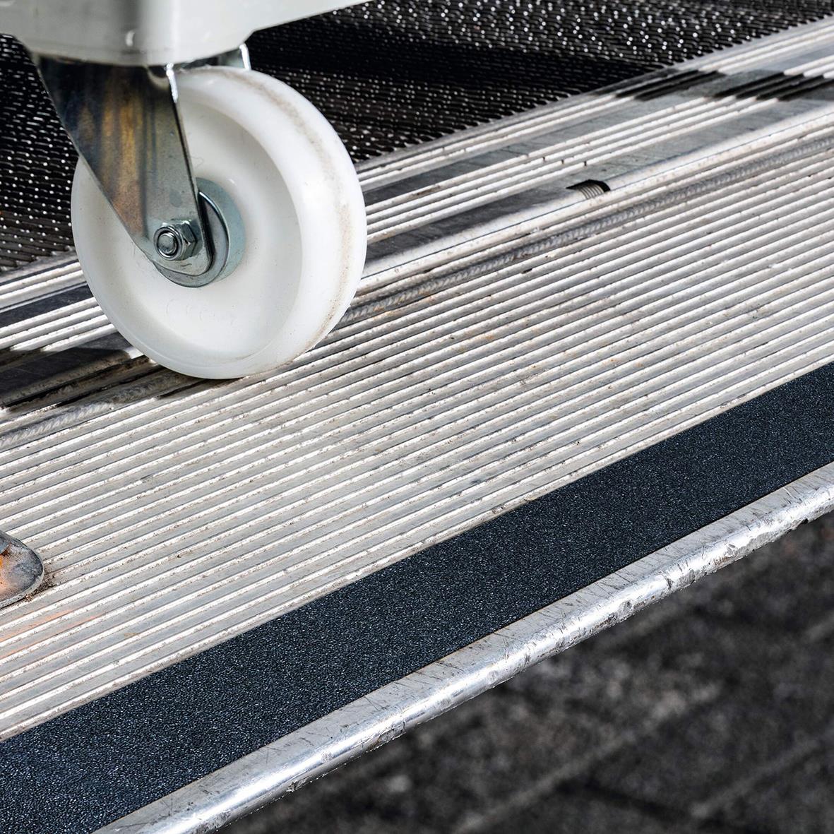 Halkskyddstejp på trappsteg med svart gripyta och hjul