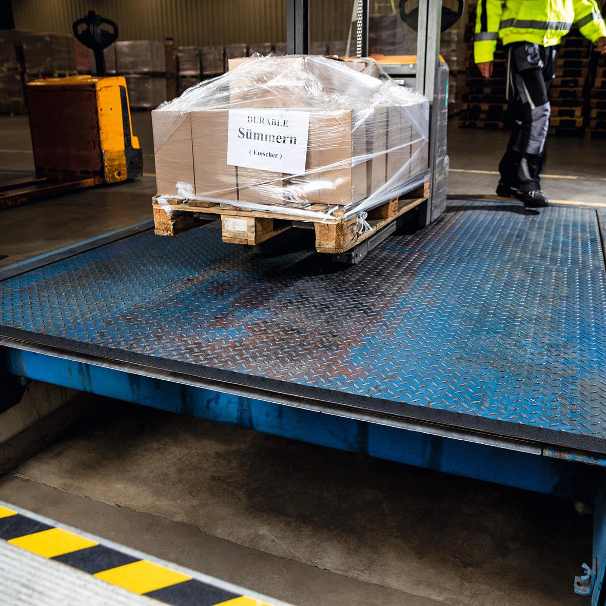 Pall med kartonger på lastbrygga med halkskyddstejp i industriell miljö