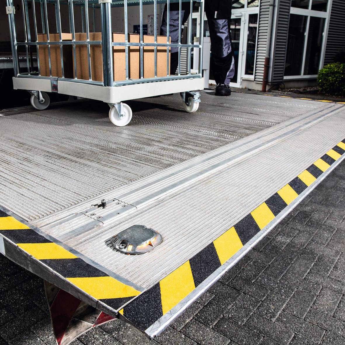 Halkskyddstejp på ramp med gul/svart varningsmönster för säkerhet