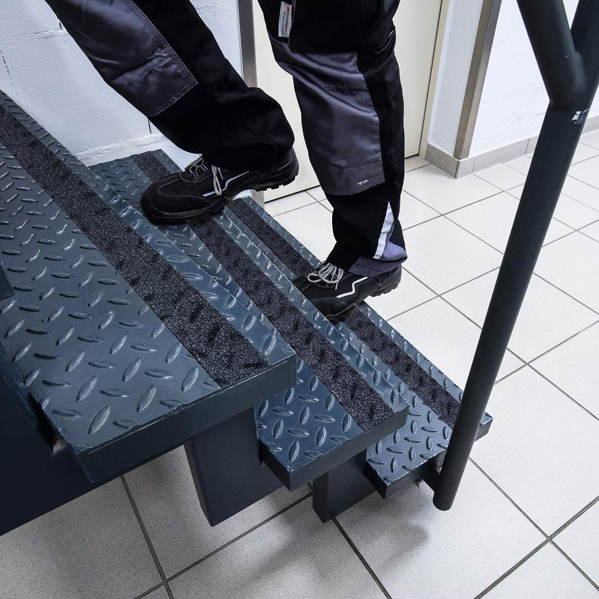Person som går på halkskyddstejp Duraline Grip+ Formfit svart på trappsteg inomhus