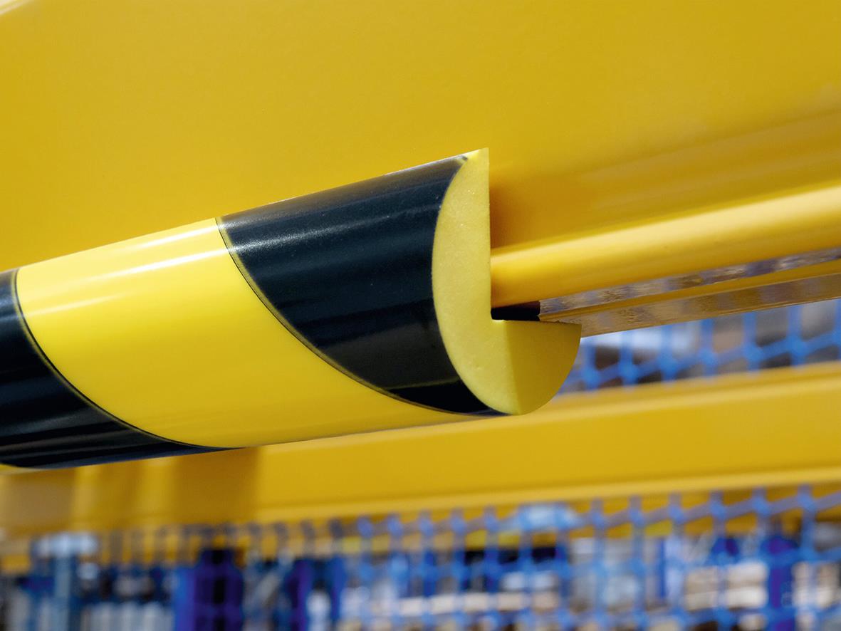 Hörnskydd i gul och svart med magnetisk funktion på en industriell hylla