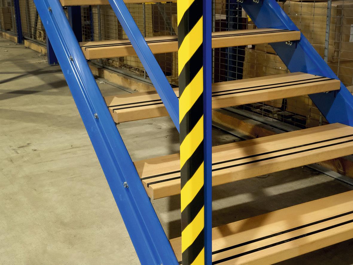 Hörnskydd i gul och svart med magnetisk funktion på blå industriell trappa