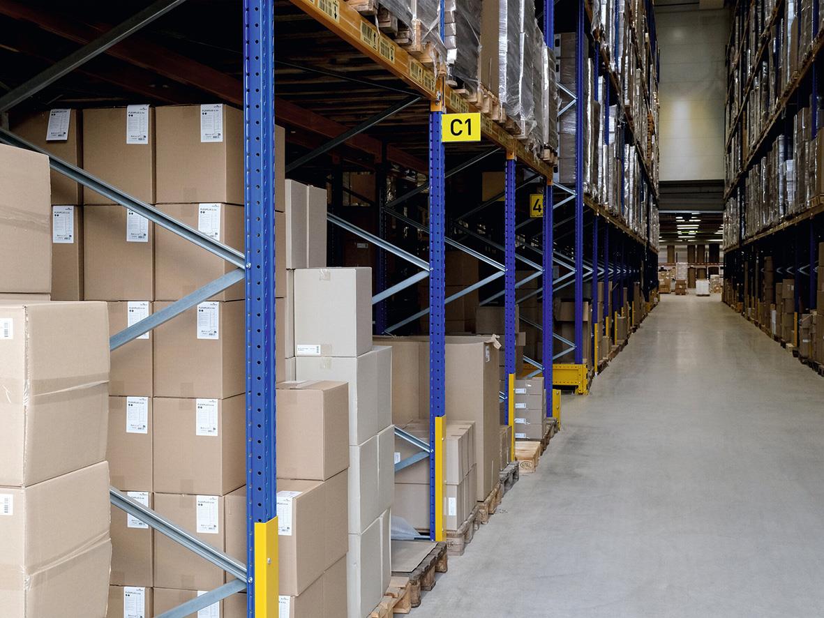 Lagerhyllor med kartonger i ett lager, tydlig gångväg