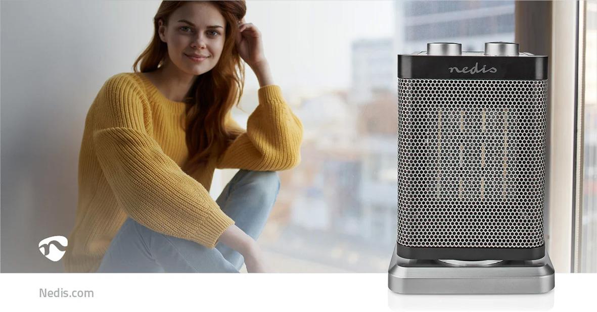 Kvinna i gul tröja bredvid en Nedis keramisk värmefläkt 1000/1500W