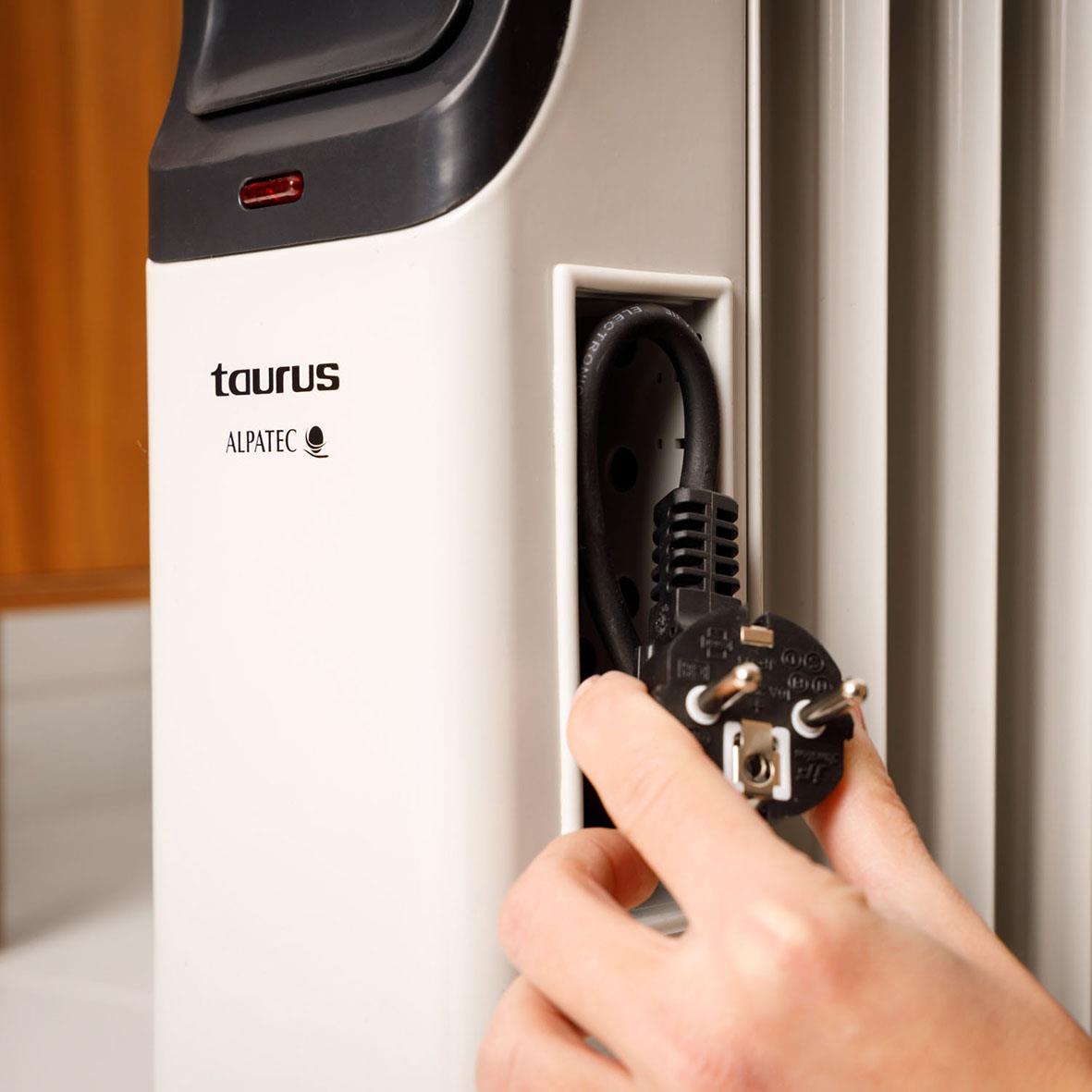 Person kopplar in en oljeradiator i ett vägguttag