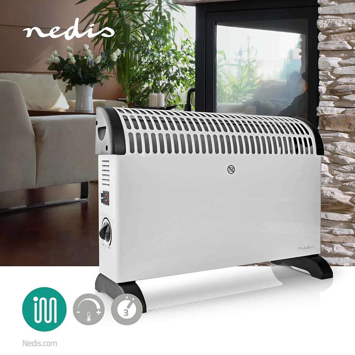 Vit Element Nedis 2000W elradiator i ett vardagsrum med växter och fönster i bakgrunden