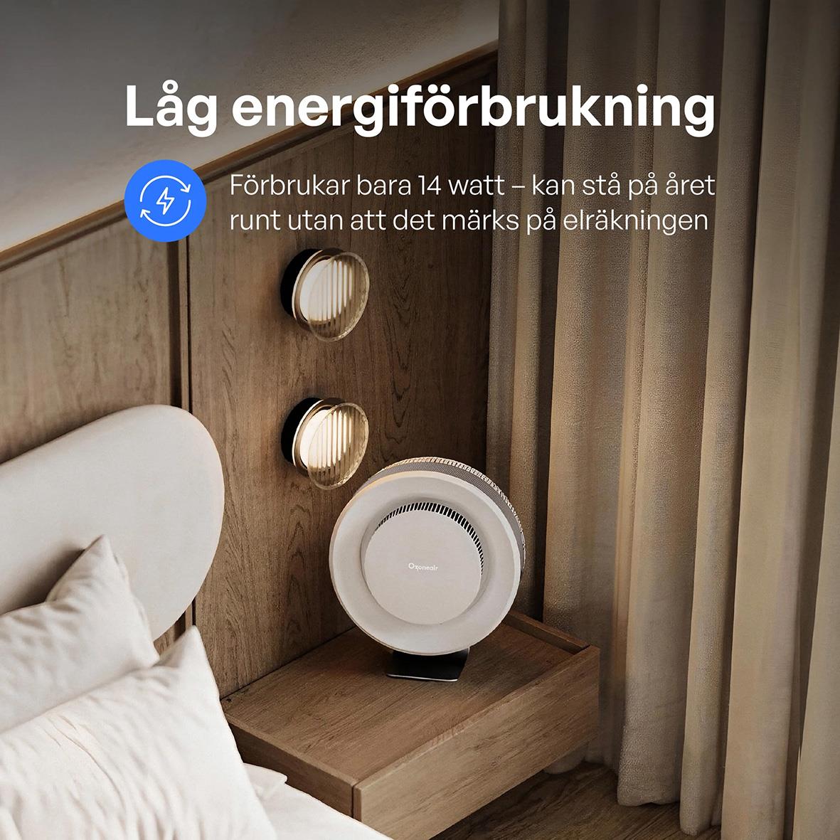 Luftrenare Ozoneair Purify 60 Pro på ett nattduksbord med trävägg och gardin i bakgrunden, visar låg energiförbrukning och 14 watt förbrukning.