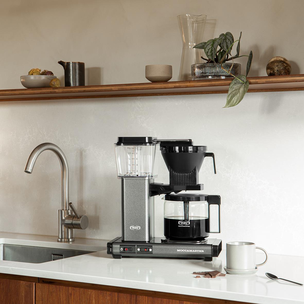 Kaffebryggare Moccamaster Automatic Antracit på köksbänk med kopp och växt