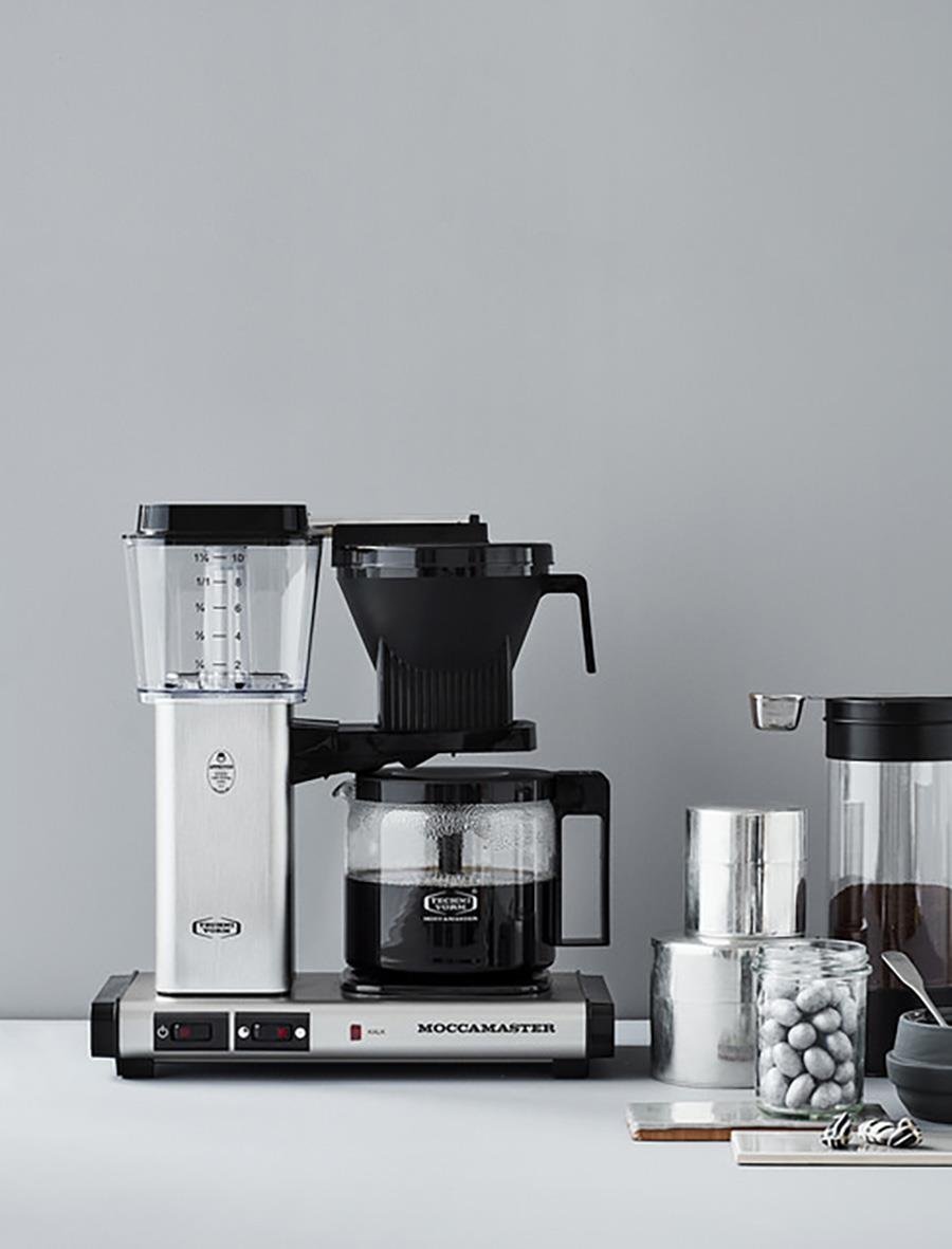 Kaffebryggare Moccamaster Automatic Brushed med tillbehör och behållare på en vit yta