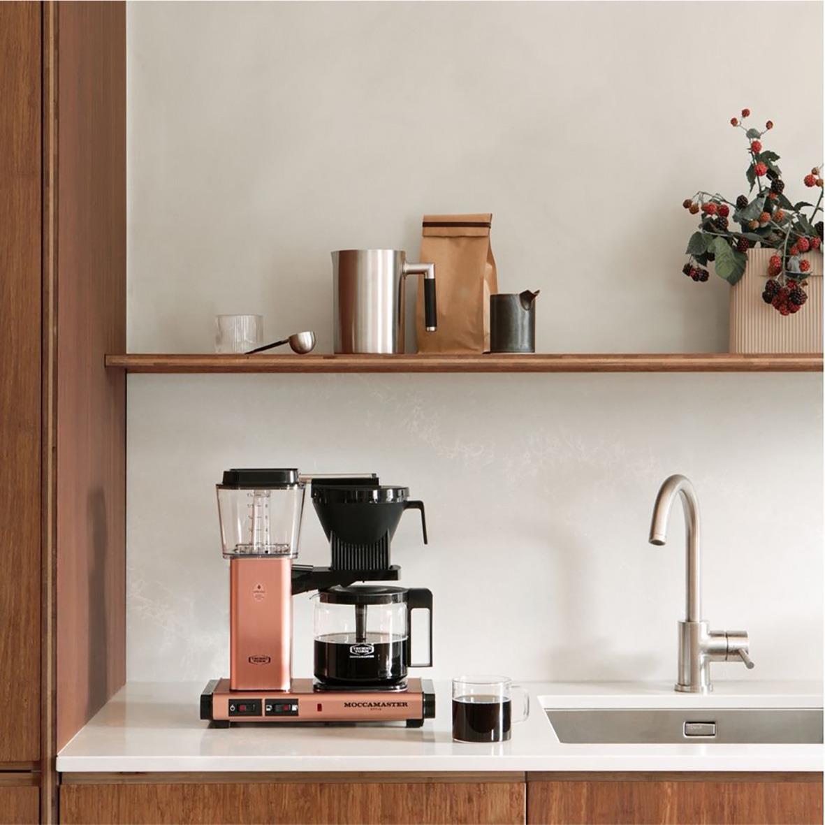 Kaffebryggare Moccamaster Optio i roséguld på köksbänk med kaffekopp och köksdetaljer