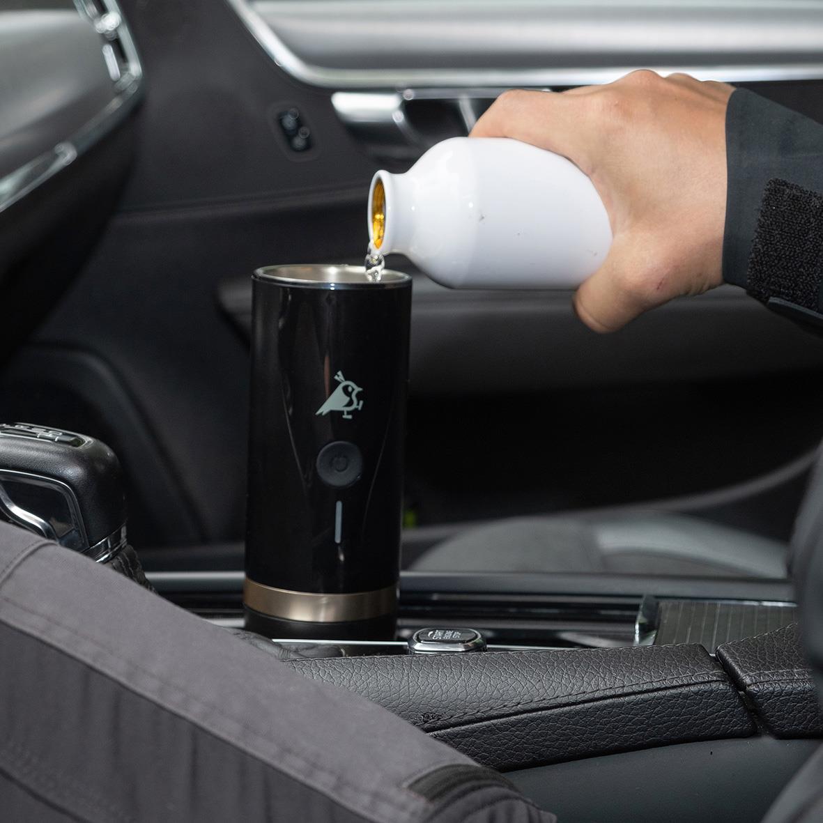 Person häller vätska i en batteridriven espressomaskin i bilens mittkonsol