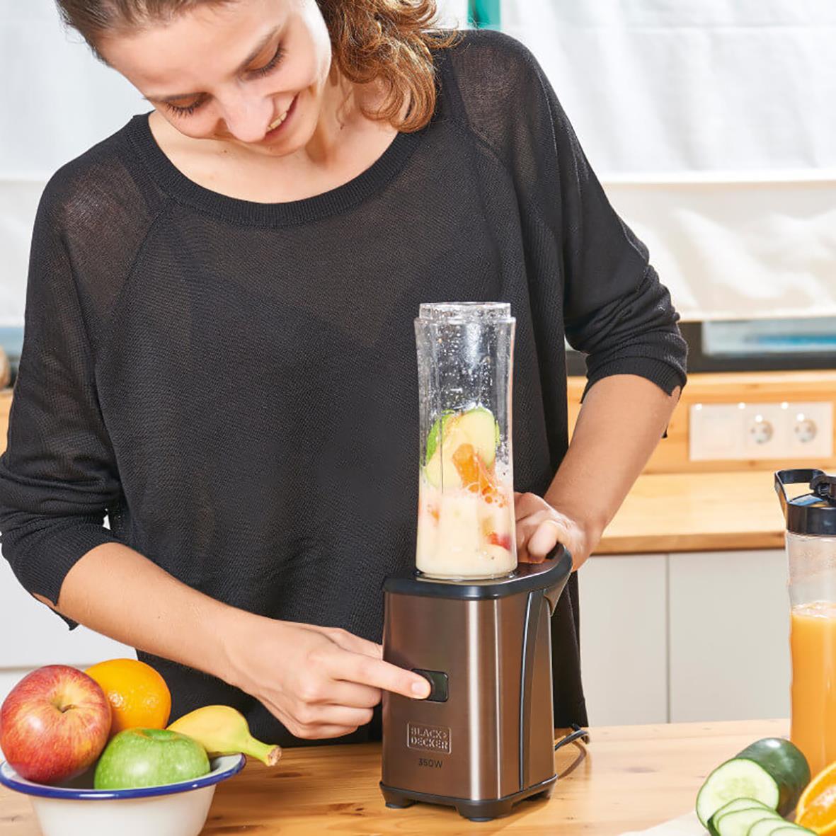 Kvinna använder Blender Black+Decker smoothie to go 350W för att blanda en smoothie i köket