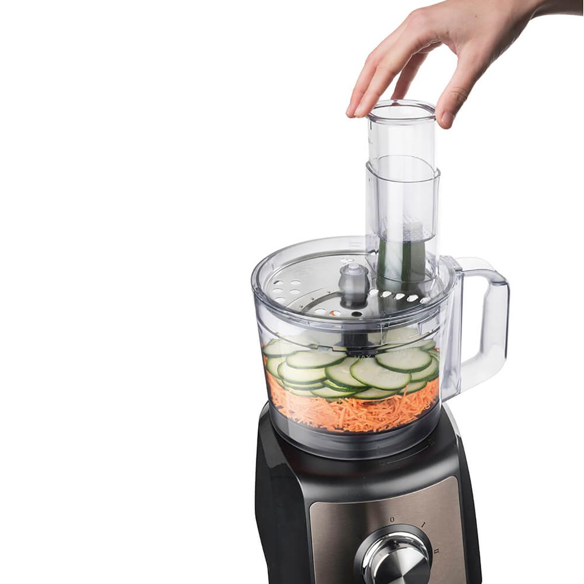 Matberedare Black+Decker 1200W med transparent behållare och hand som placerar ingredienser