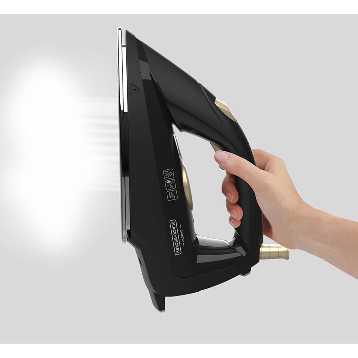 Hand som håller en svart ångstation Black+Decker 2400W 2L, avsedd för att skapa ånga