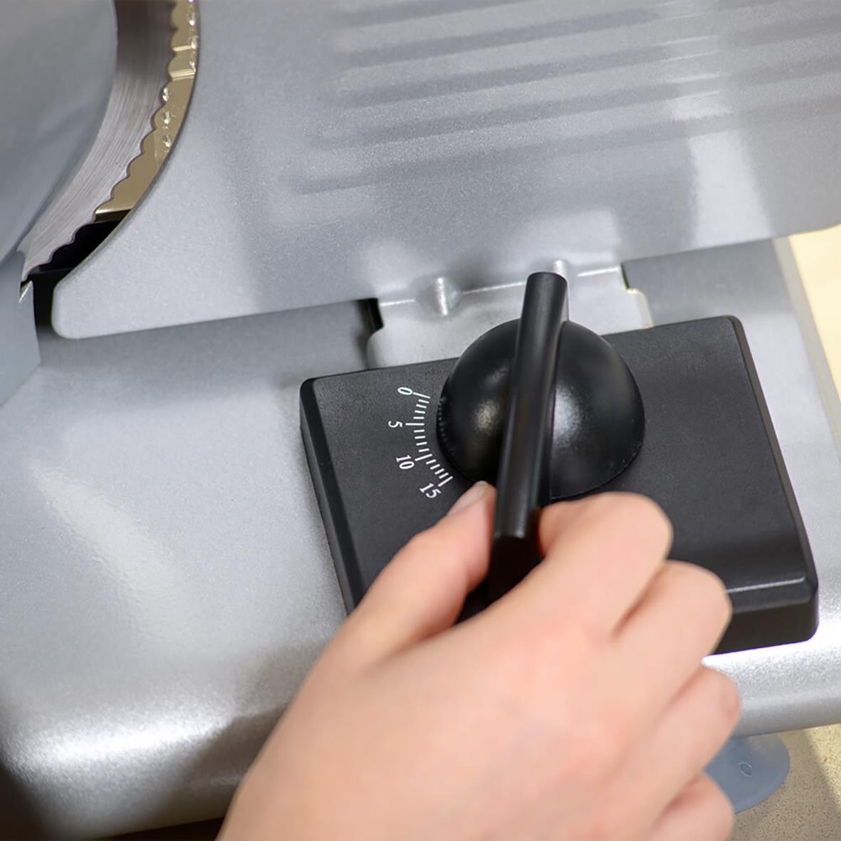 Hand som justerar inställningar på Taurus Cutmaster 1520W skärmaskin