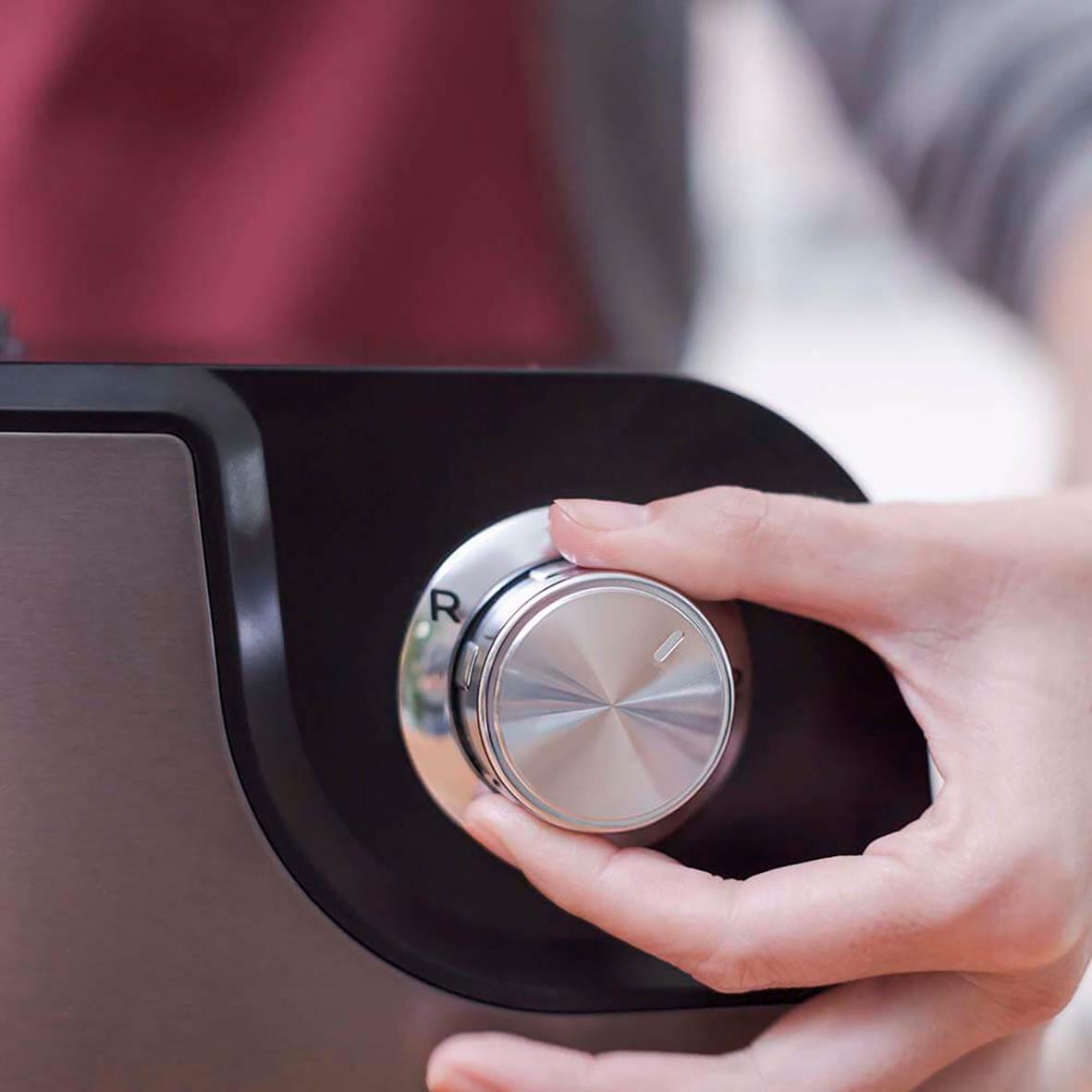 Hand som justerar inställningar på en köttkvarn Black+Decker 1000W