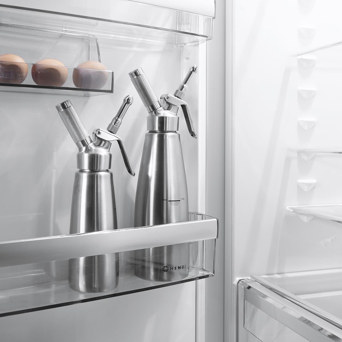 Två metallkannor med sprutmunstycken i ett kylskåp