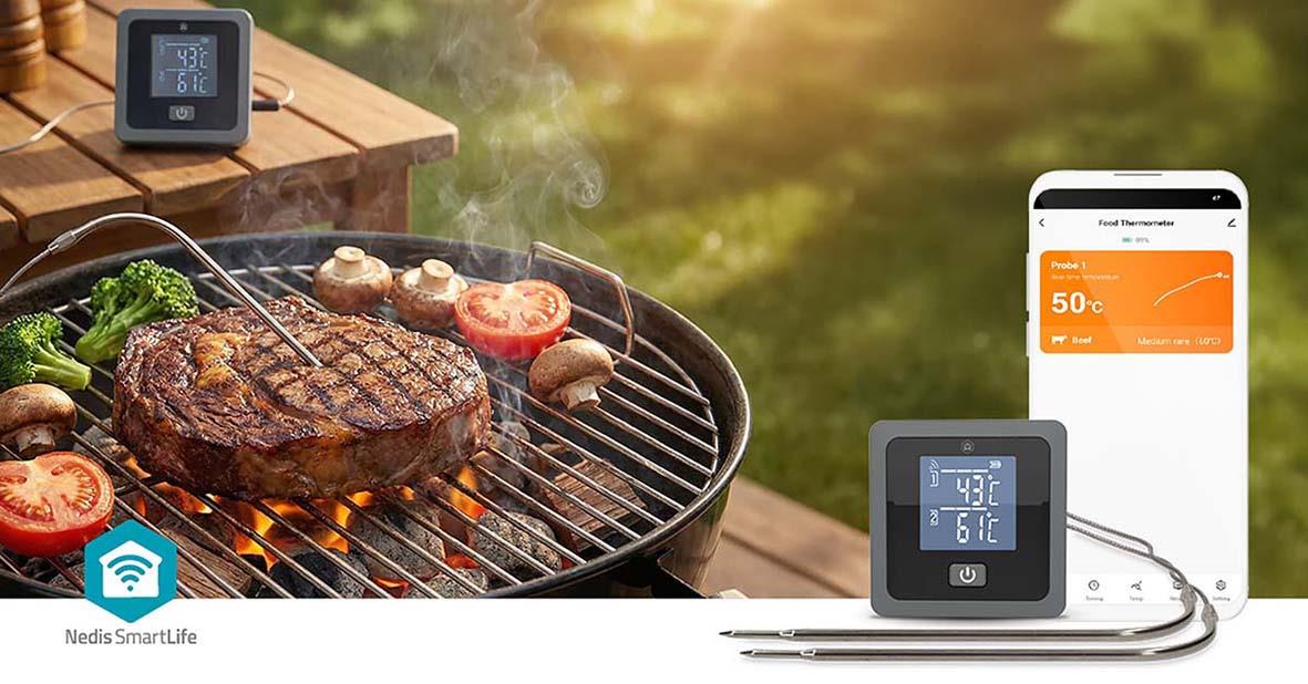 Grill med kött, tomater och grönsaker, digital termometer och smartphone för matlagning