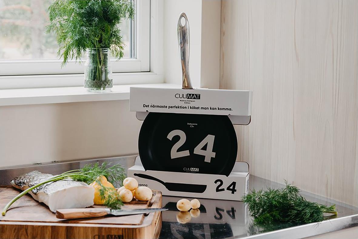 Stekpanna Culimat Mathias Dahlgren Ø24cm placerad på en bok, med köksredskap och grönsaker i ett kök